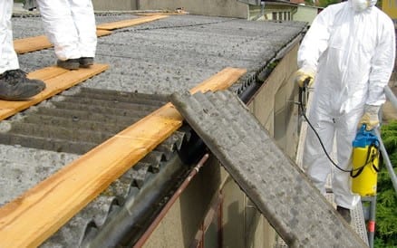 Verwijderen asbesthoudende golfplaten met gebruikmaking van de juiste gereedschappen en veiligheidsvoorzieningen.